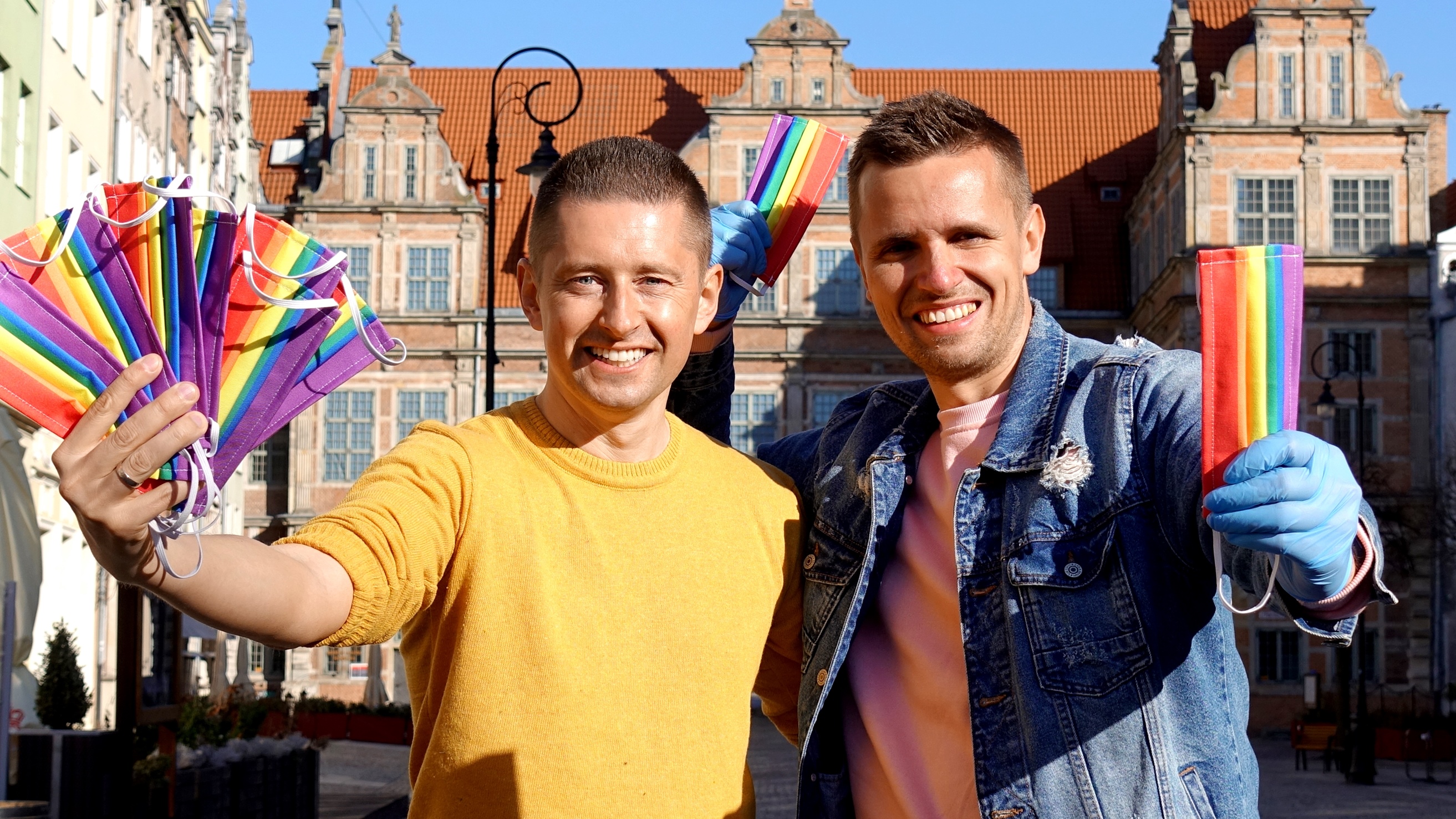 Una pareja gay reparte mascarillas arcoíris contra la pandemia de la LGTBIfobia