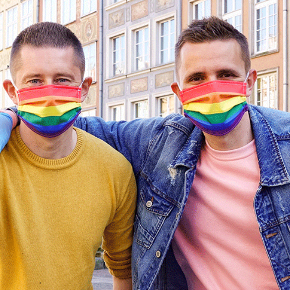 Una pareja gay reparte mascarillas arcoíris contra la pandemia de la LGTBIfobia