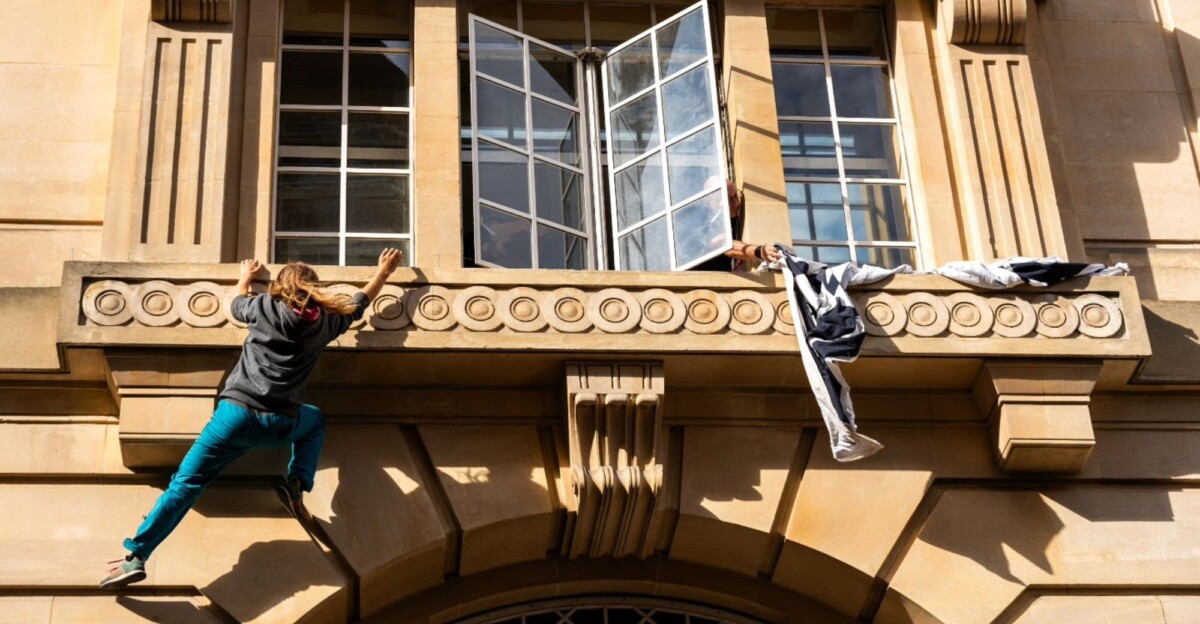 Grin, activista, escalando la fachada del Departamento de Educación