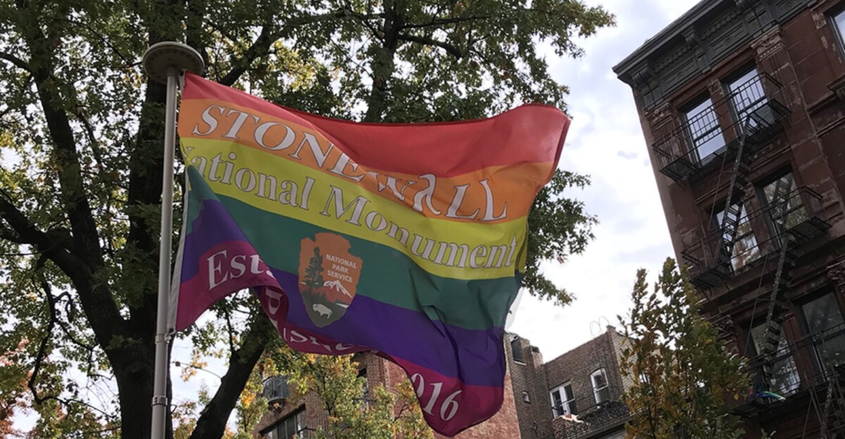 Bandera LGTBIQ+ con el logo de 'Stonewall National Monument'