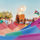 Imagen de la gran bandera arcoíris del desfile.