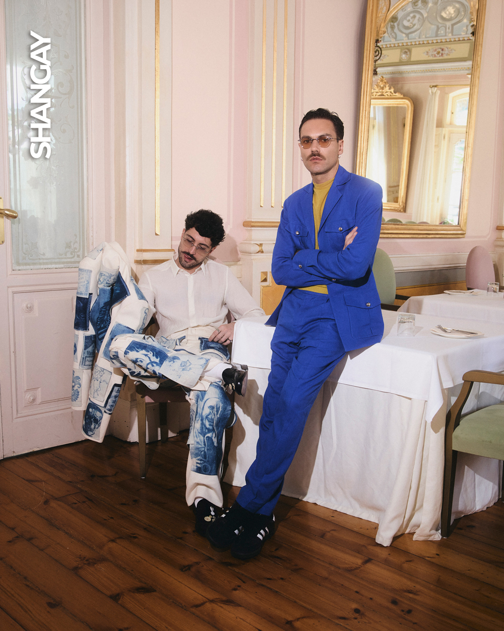 Joshua Velázquez y Alberto Jiménez en su primer reportaje como pareja en Asturias. Joshua lleva camisa <a href="https://www.antonymorato.com/es/" target="_blank" rel="noopener">Antony Morato, </a>chaqueta y pantalón <a href="https://www.instagram.com/casacalafat/" target="_blank" rel="noopener">Álvaro Calafat</a>, zapatos Hune y gafas <a href="https://carlmartincm.com/" target="_blank" rel="noopener">Carl Martin</a>. Alberto lleva traje <a href="https://www.palomasuarez.com/" target="_blank" rel="noopener">Paloma Suárez</a>, top <a href="https://www.adolfodominguez.com/site-selector" target="_blank" rel="noopener">Adolfo Domínguez</a>, zapatillas Adidas y gafas <a href="https://carlmartincm.com/" target="_blank" rel="noopener">Carl Martin</a>.